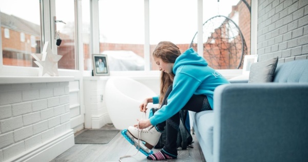 Little girl putting on ice skates before going outside her conservatory 2