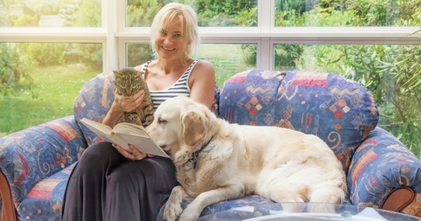 Woman reading in conservatory with her pets 2