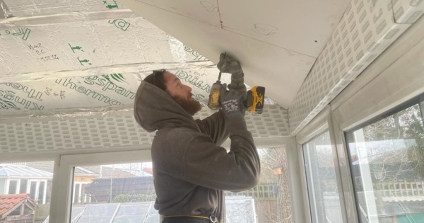 A man cutting the insulated plasterboard for a conservary roof conversion 2