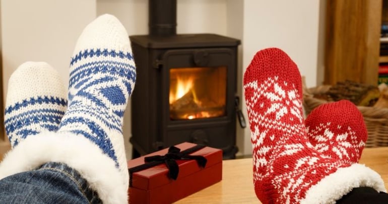 A couple in front of a woodburner enjoying their newly converted conservatory