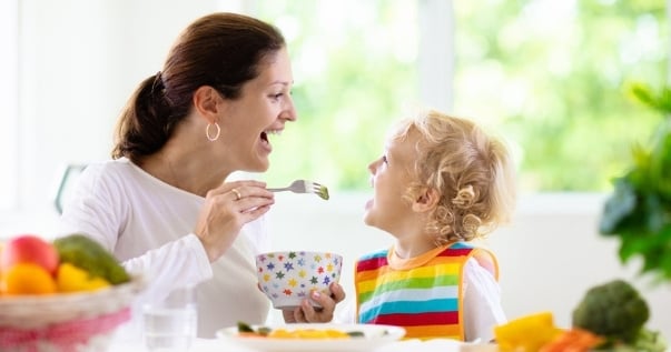 Mother feeding child in conservatory breakfast nook created out of a transformed conservatory.