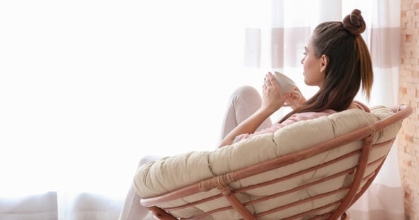 Woman enjoys coffee on a winter morning in her comfortable nook since she transformed her conservatory into an insulated one. It’s time to transform your conservatory.