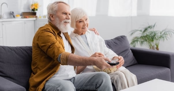 Mature couple watching a movie in their conservatory after they replaced their conservatory roof with a guardian roof. (1)