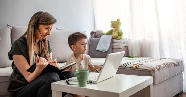 Mother working at home with her son next to her inside their converted conservatory.