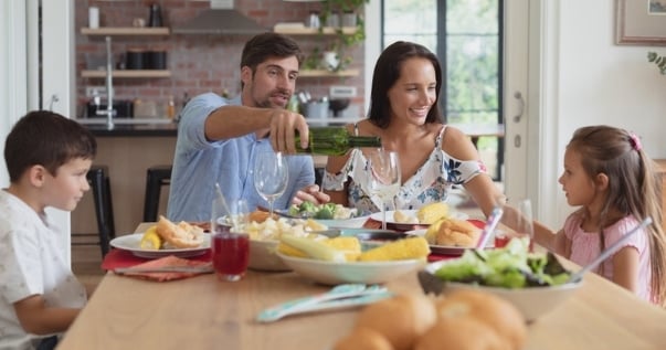 Happy family having lunch at their conservatory after a guardian warm roof conversion thanks to its insulation.