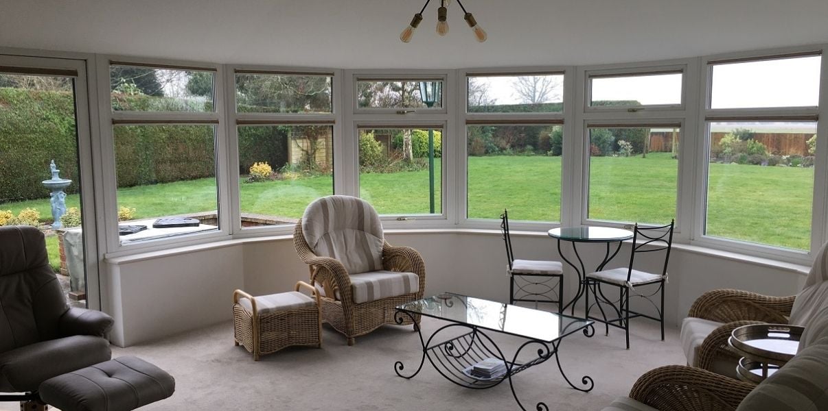 Cosy conservatory with a garden view and a solid roof