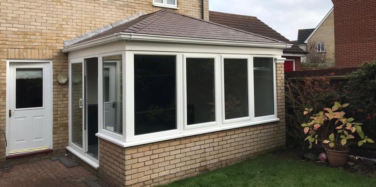 Transformed edwardian conservatory with a solid roof on a cloudy day