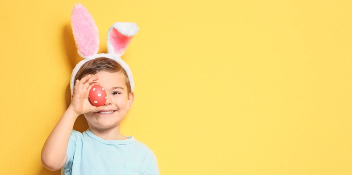 Cute young boy having an Easter egg hunt in his homes solid roof conservatory