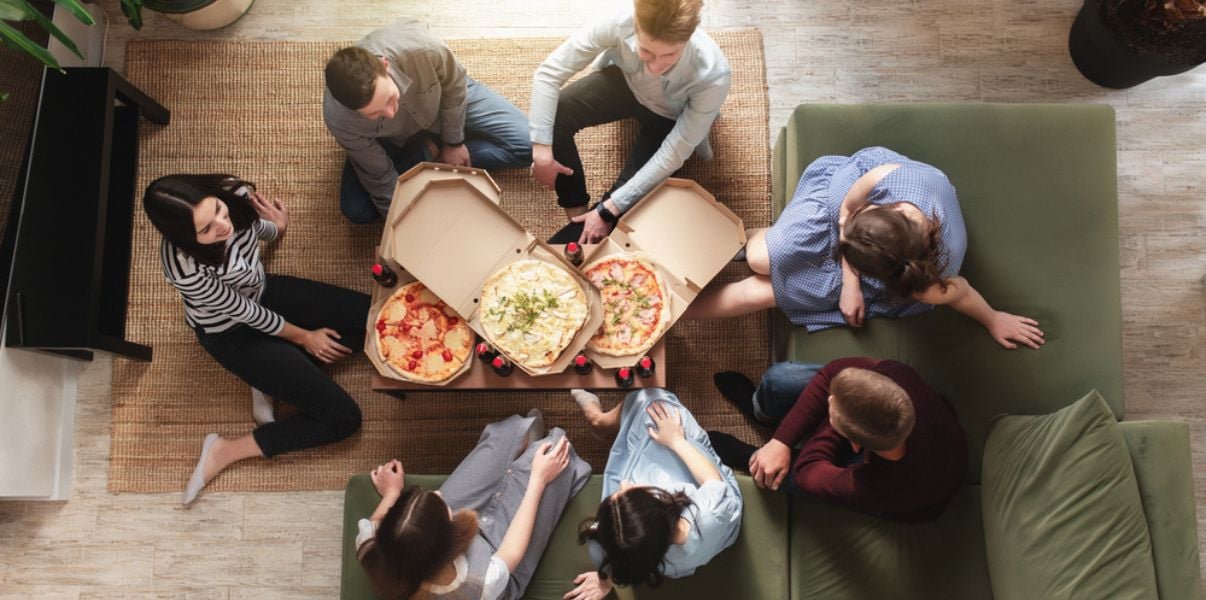 Group of friends enjoying a pizza dinner in a colis roof conservatory