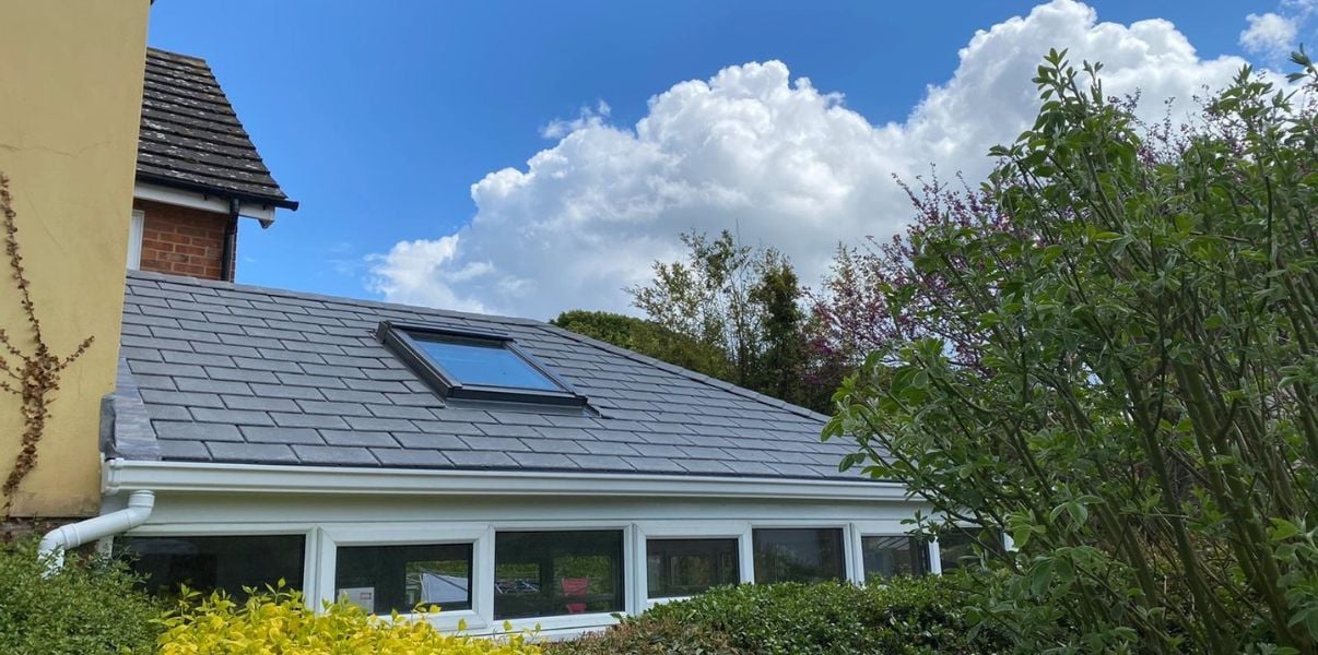 Charming solid roof conservatory with a window on a cloudy day