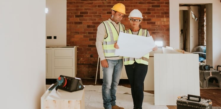 Man and woman observing project blueprints for conservatory roof replacement project