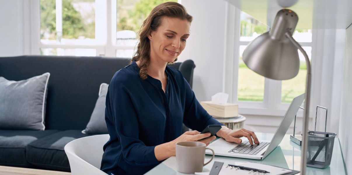 Happy woman working from her homes insulated conservatory