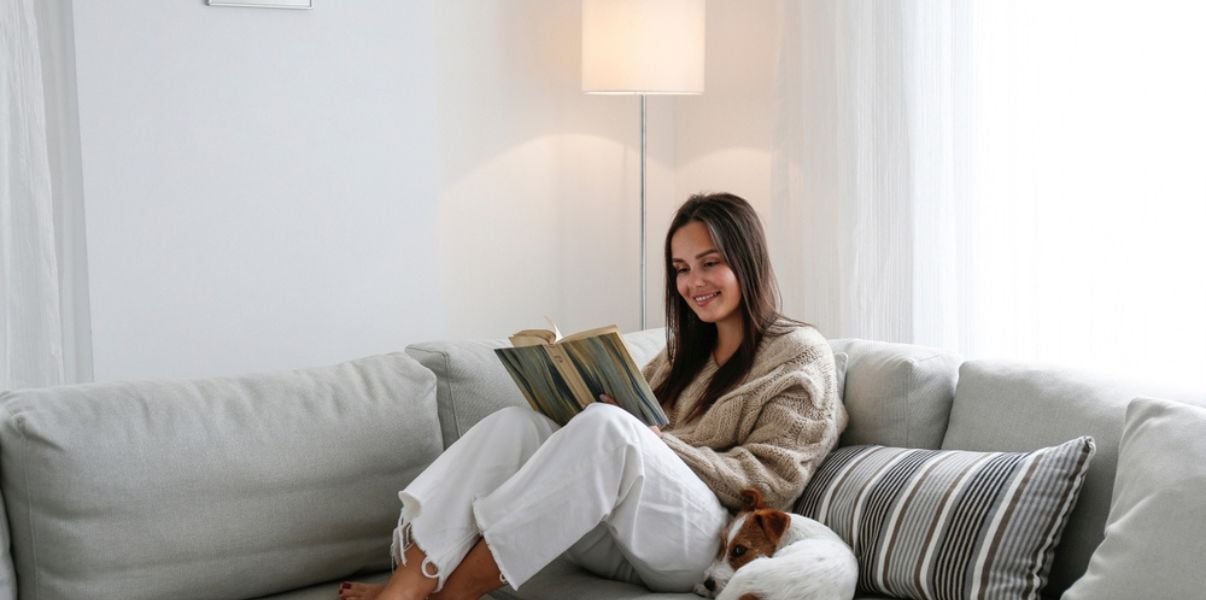 Brunette woman reading a book in her warm insulated conservatory