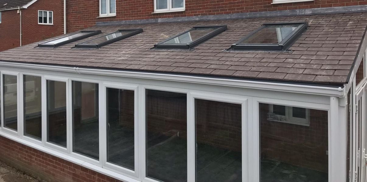 Quaint solid roofed conservatory with Velux windown on its roof