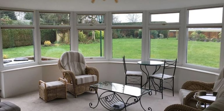 Cosy conservatory with a solid conservatory roof and a beatuiful garden view