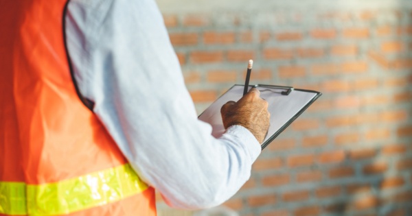 Builder checking if all his workers are insured before a conservatory roof replacement