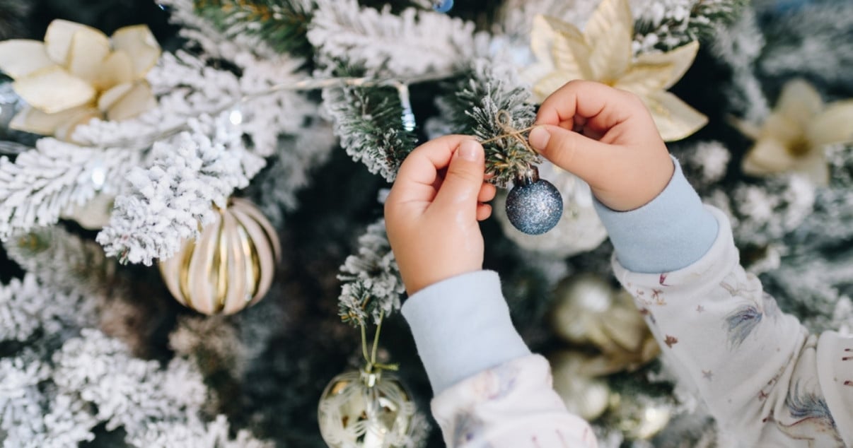 Young girl setting up the Christmas tree in her Conservatory after her parents went through a Conservatory conversion